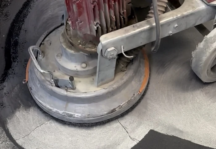 Professional concrete grinding to remove an old garage floor coating