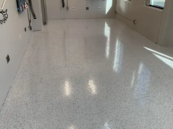 Bright residential garage with clean gray decorative flake epoxy floor