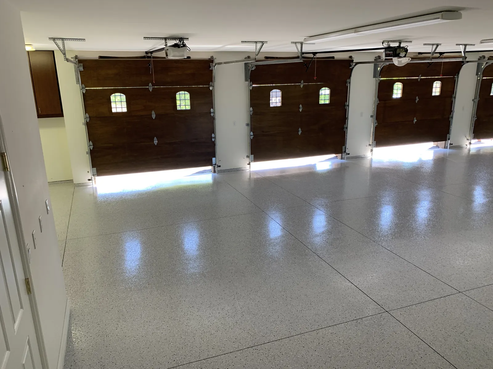 Large three-bay residential garage with a finished gray floor coating for Meridian Idaho homes